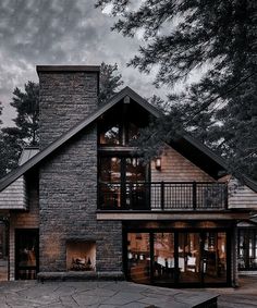 a large house with a stone fireplace and deck