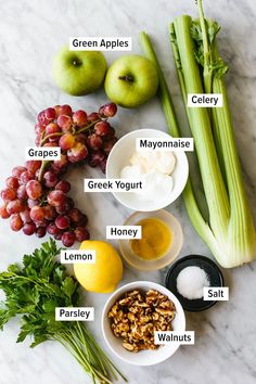 the ingredients to make an apple cider are displayed on a marble counter top, including celery, grapes, mayonnaise, green yogurt, lemons, walnuts and parsley