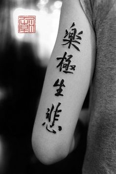 a person with a tattoo on their arm that has chinese characters written in black ink