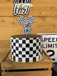 a black and white checkerboard cake with two fast stickers on the top