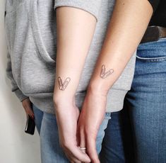 two people with matching tattoos on their arms