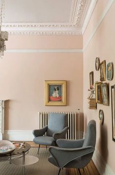 a living room filled with furniture and pictures on the wall next to a radiator