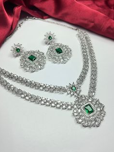 Gorgeous fine quality replica diamond and emerald green studded necklace with a white  rhodium plating and matching Earrings Item contains: Necklace and earrings AAA-quality cubic zirconia was used. Highest quality and craftsmanship Necklace Fitting is adjustable Earrings Closure: Pushback Necklace Closure: chain with Hook Elegant Silver Emerald Necklace With Stone Work, Elegant Silver Kundan Necklace With Emerald, Traditional Cubic Zirconia Emerald Necklace For Wedding, Silver Emerald Jewelry Sets With Elegant Design, Traditional Emerald Jewelry For Party, Silver Kundan Necklace With Hand-set Emeralds, Traditional Hand-set Cubic Zirconia Emerald Necklace, Hand Set Green Cubic Zirconia Bridal Earrings, Elegant Emerald Jewelry Sets With Stone Work