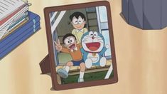 an image of dora the cat and her son in front of a photo frame on a table