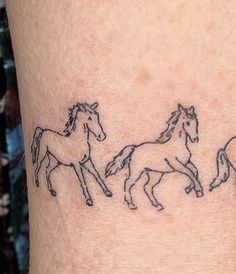 three horses running in a line on the side of a woman's leg with black ink