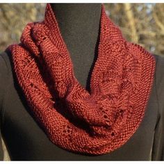 a woman wearing a red knitted scarf on top of a mannequin head