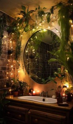 a bathroom with plants and lights on the wall above the sink, along with a round mirror