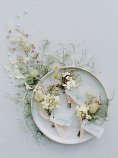 flowers are arranged on a plate with the names of their wedding guests and place cards