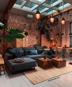 a living room filled with lots of furniture and plants on the wall above it's windows