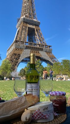 a bottle of wine and some cheese on a table in front of the eiffel tower