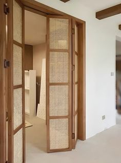 an open wooden door in a white room