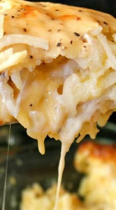 a piece of lasagna being lifted from a casserole dish with cheese