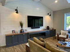 a living room with two couches and a flat screen tv mounted on the wall