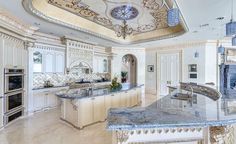 a large kitchen with marble counter tops and an island in front of the stove top