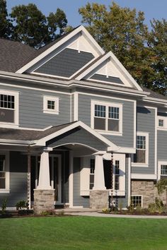 two story house with gray siding and white trim on the front, green grass in front