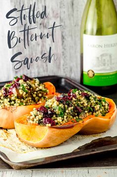 two stuffed sweet potatoes on a tray next to a bottle of wine