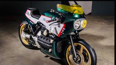 a green and white motorcycle parked in a garage