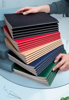 a stack of books being held by someone's hand on top of each book