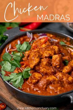 chicken madras in a skillet with cilantro and red peppers