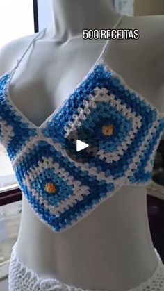 a crocheted blue and white top on a mannequin's torso