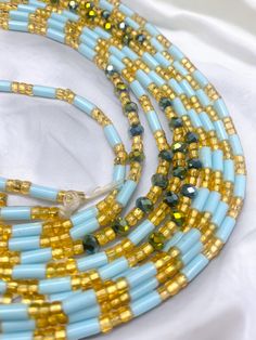 Single Strand Waist Bead Senoufo harmonizes the beauty of light blue crystal glass seed beads with the timeless elegance of gold glass seed beads. This handcrafted masterpiece captures the essence of sophistication, inviting you to adorn yourself with grace and style. 🌊 Light Blue Crystal Glass Seed Beads: Reflecting the tranquil hues of the sky and sea, the light blue beads exude calm and serenity. Blue signifies wisdom and clarity, empowering you with a sense of purpose. 🌟 Gold Glass Seed Be Adjustable Gold Oval Waist Beads, Blue Waist Beads With Spacer Beads As Gift, Blue Beaded Waist Beads As Gift, Blue Colorful Waist Beads As Gift, Gold Rondelle Beaded Necklaces For Spiritual Style, Gold Round Waist Beads For Gifts, Turquoise Beaded Bracelets With Gold Beads, Turquoise Beaded Bracelets With Gold Accents, Gold Oval Beads Bohemian Style