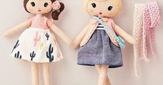 two dolls are standing next to each other with clothes hanging on the wall behind them