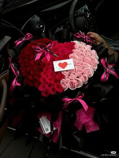 a car decorated with pink and red roses in the shape of a heart is shown