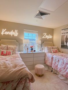 two beds in a bedroom with pink and white decor