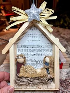 a nativity scene made out of sheet music and wooden dows with a star on top