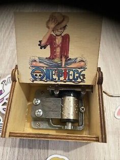 an old style music box with a clock in the bottom and some stickers around it