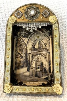 an old photo frame with gold trimmings and ornate designs on the edges, in front of a white background