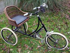 an old fashioned bicycle with a basket on the front and seat is parked in grass