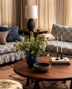 a living room filled with furniture and a table in front of a window covered in curtains