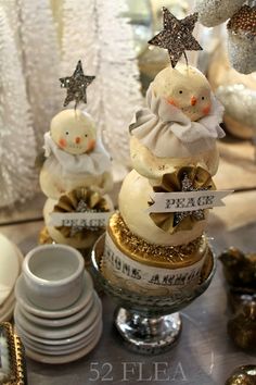 three snowmen sitting on top of each other in front of plates and silverware