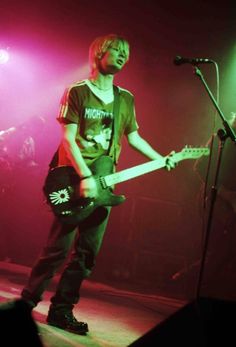 a young man playing an electric guitar on stage