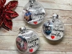 three glass christmas ornaments with dogs and hearts on them, one is saying i love you more than the other