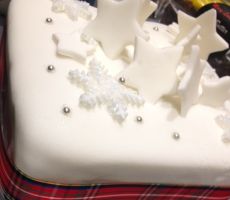 there is a white cake decorated with stars and snowflakes on it's side