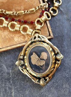 "A Reliquary for a cherished 4 leaf clover and a tinted tintype of a young boy, this gorgeous pendant is a Pinchbeck (named for it's inventor) Mourning Brooch, from the 1800's. Pinchbeck is an alloy of copper (mostly) and zinc, combined to closely resemble gold. It was often used in watchmaking and jewelry. These swivel brooches from the 1800's were most often filled with the hair or picture of a loved one who had passed. This double side brooch had a picture from the early 1900's in it, so I re Memento Mori Victorian, Steampunk Photography, Vintage Statement Jewelry, Assemblage Necklace, Brooch Necklace, Four Leaf, Memento Mori, Leaf Clover, Four Leaf Clover