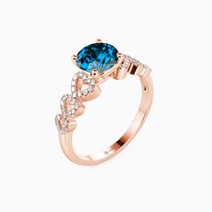 a rose gold ring with an oval blue topazte surrounded by small white diamonds