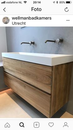 a bathroom vanity with two faucets on the top and one sink below it