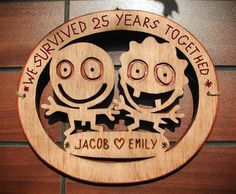 a wooden sign with two cartoon faces on it that says we survived 25 years together