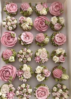 cupcakes decorated with pink and white flowers in a box