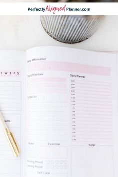 an open planner and pen sitting on top of a desk next to a cup of coffee