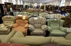 a large room filled with lots of different types of chairs and couches for sale