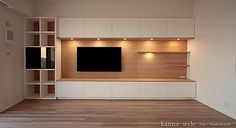 an empty living room with wooden flooring and built - in entertainment center on the wall