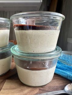 three glass containers filled with food on top of a wooden table