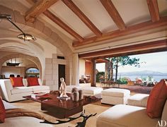 a living room filled with white furniture and lots of windows