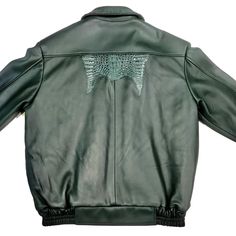 the back of a green leather jacket with an image of a bird on it's chest