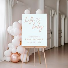 a sign that says hello baby next to balloons in the room with white and pink decorations