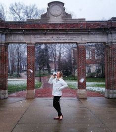 a woman standing in front of a brick archway